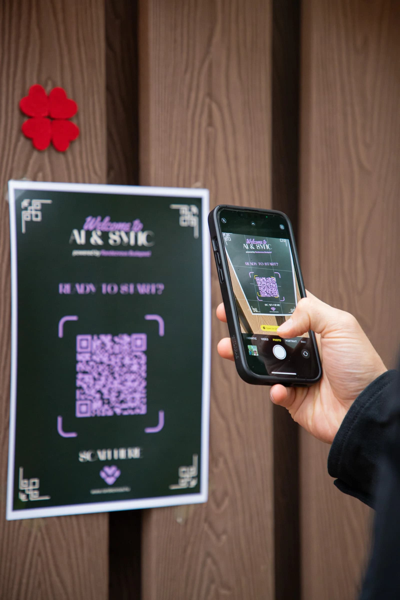 Telefon beolvassa a Welcome to AI & Sync tábla QR-kódját